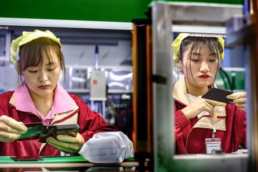 一家手机配件厂的打工人,正在岗位上进行作业