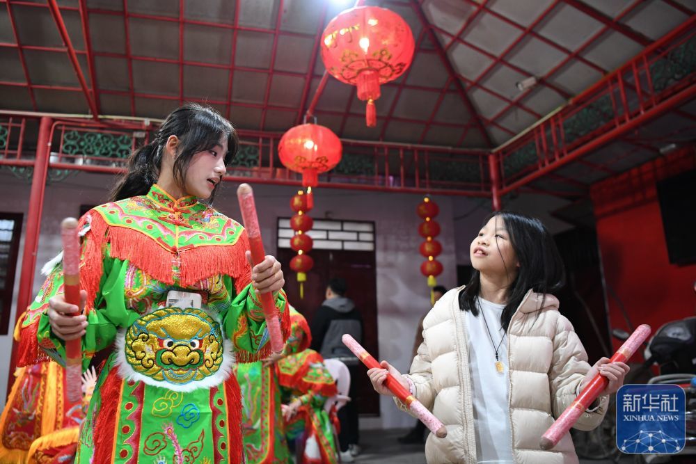 1月20日,，在廣東汕頭潮陽區(qū)的西龍古廟,，西門女子英歌隊隊員在指導小朋友領會英歌動作要領。