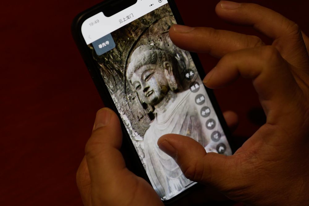 4月17日，游客使用“云上龙门”手机小程序游览龙门石窟。