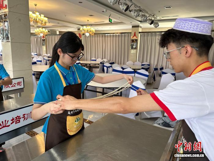 图为拉面师傅手把手指导港青拉面技巧 王牧雨 摄