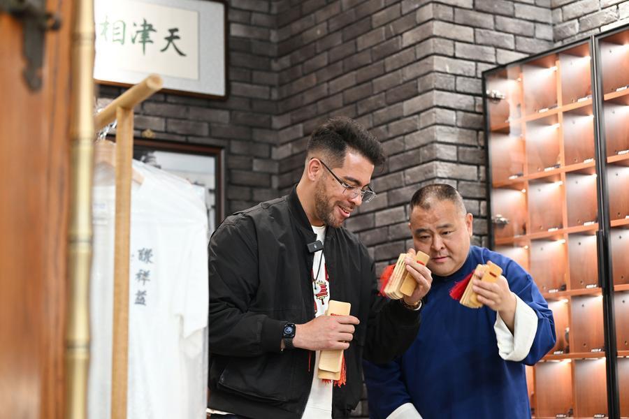 4月24日，在天津市红桥区谦祥益相声茶馆，演员王文水（右）指导吴瑞龙打快板。