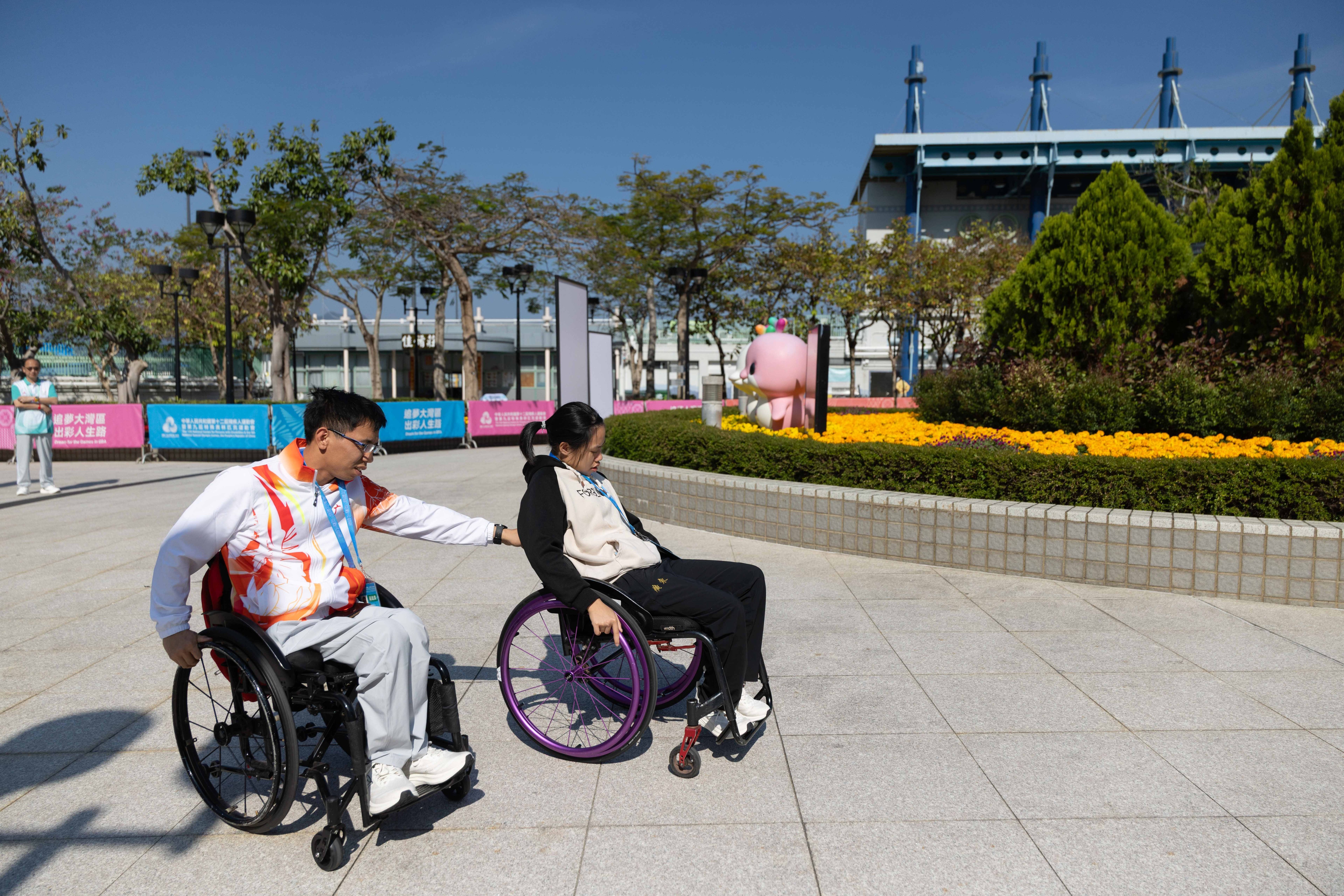 香港马鞍山体育馆外，梁绍颖帮顾文茜推轮椅。