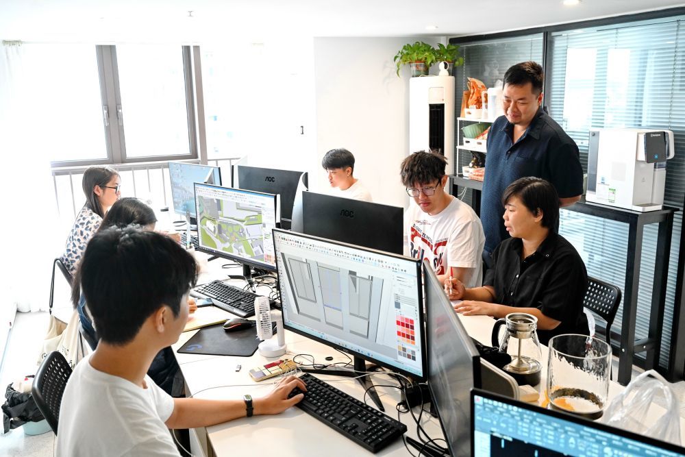 2024年8月14日，台湾青年陈榆文（右一）和创业伙伴陈龙（右二）等在公司办公室讨论设计方案。新华社记者 林善传 摄