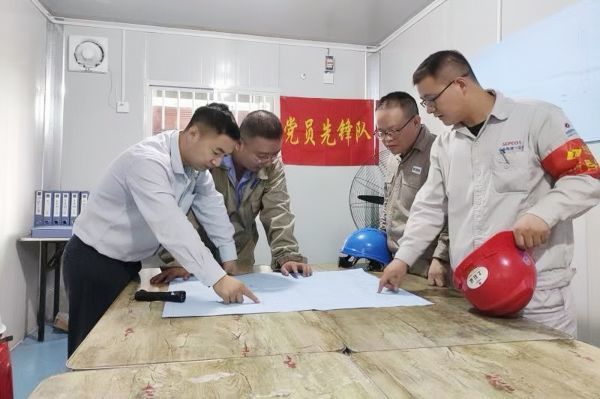 图为福建泉州公司供热党员先锋队成员现场对照图纸进行讨论(1)