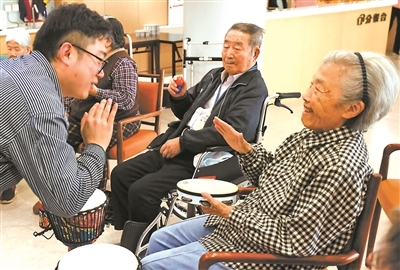 王瀚林(左)带领社区音乐小组开展每周一次的打击乐互动和音乐欢唱