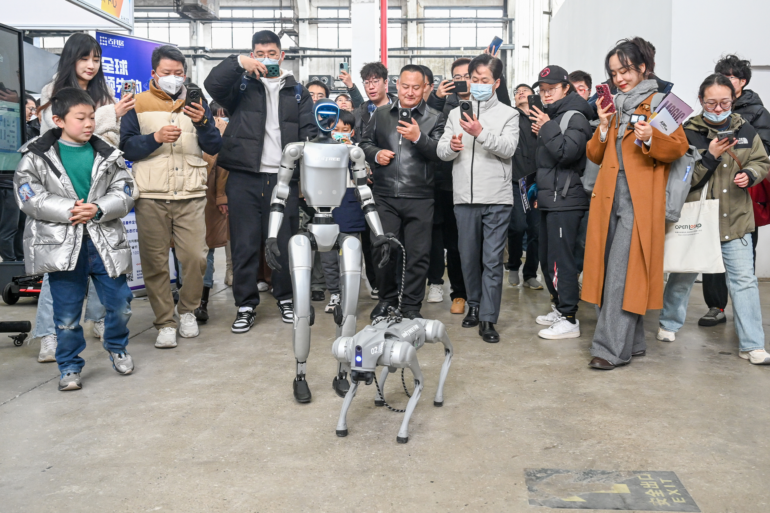 2025年2月22日,上海西岸艺术中心,宇树机器人现场“遛狗”,吸引众多观众围观。澎湃新闻记者 朱伟辉 图