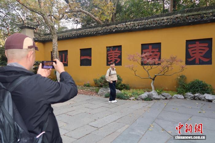 12月1日，游客在杭州灵隐飞来峰景区内拍照留念。孙琳茹　摄