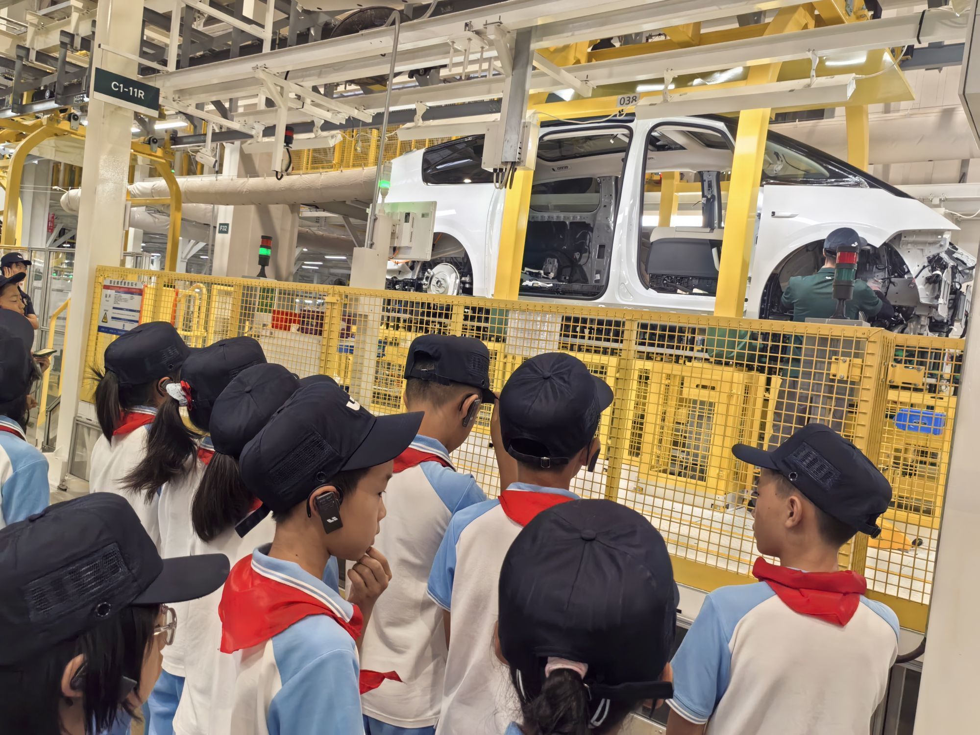 在理想汽车智能工厂，孩子们正在观看汽车如何组装。