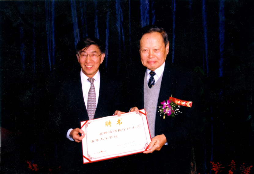 1999年,杨振宁(右)从时任清华校长王大中(左)手中接过清华大学聘书。(清华大学供图)