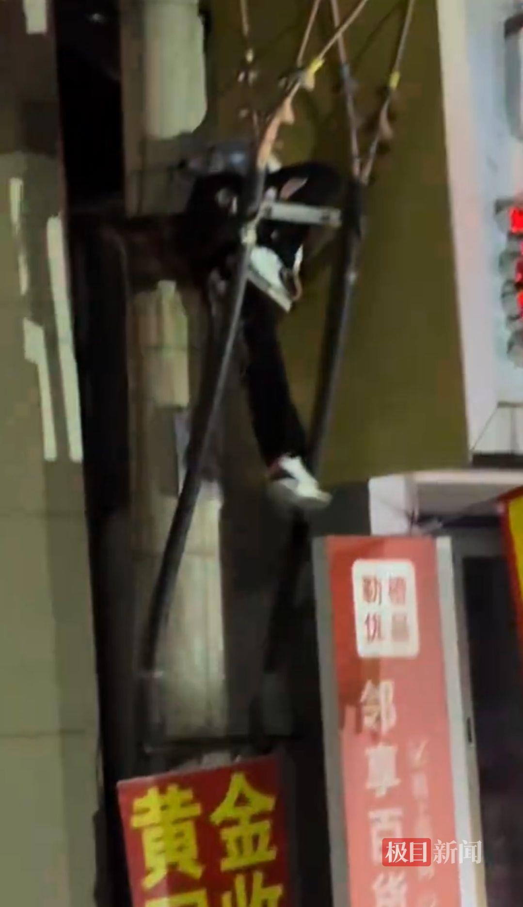 山西太原一男子挂在高压电线杆支架处(受访者供图)