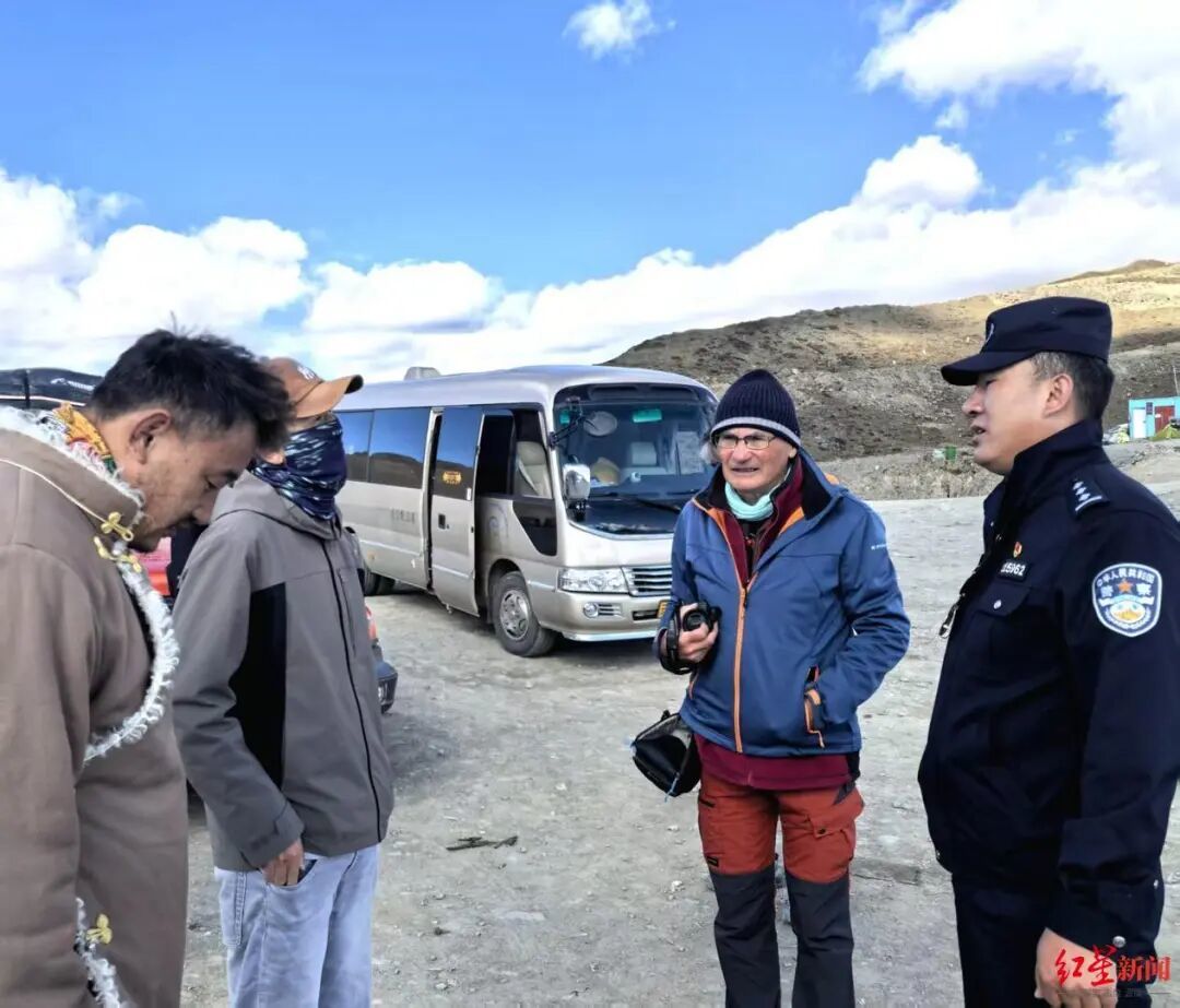 ▲在子梅垭口处,李邓珠(右一)向外国游客介绍当地住宿情况