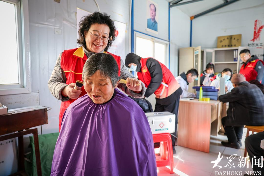 志愿者于志芹为村民理发。