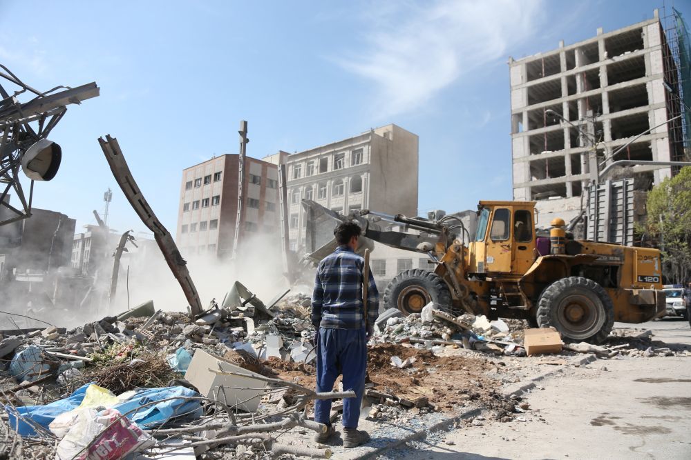 3月4日，在伊朗首都德黑兰，一名男孩查看被损毁的建筑。