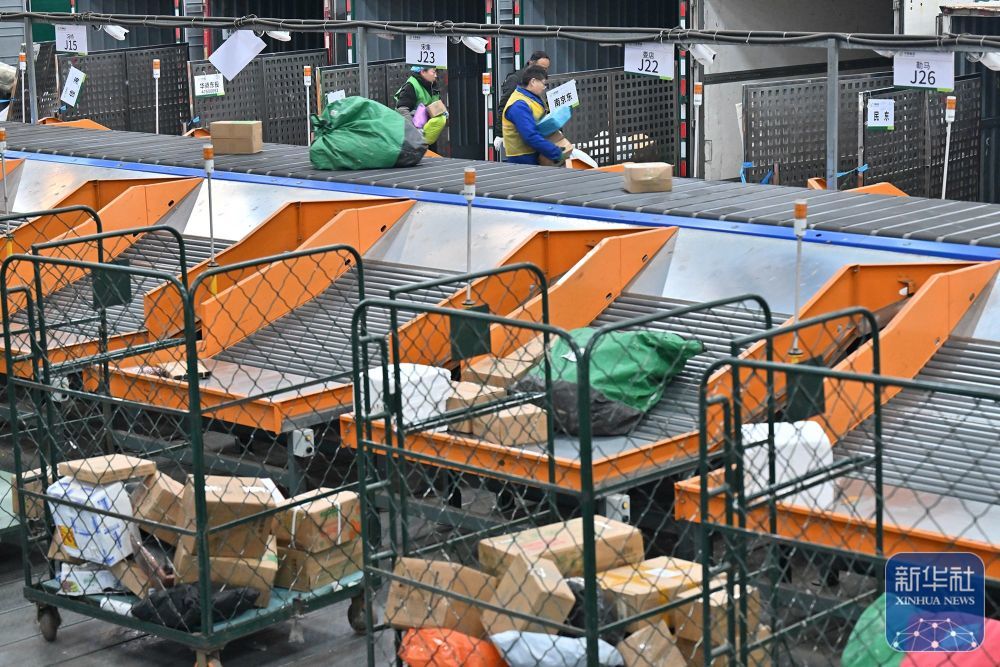 ↑ 1月2日,工作人员在中国邮政集团有限公司商丘市分公司邮件处理中心搬运快递。新华社发(李恒摄)