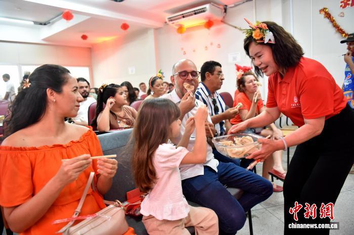 2026年中国农历新年适逢巴西狂欢节。当地时间2月16日，在巴西东北部北里奥格兰德州阿波迪小镇，巴西农户、农业专家和中国农业大学师生们在阿波迪科技小院里联欢。图为小院首席专家、中国农业大学工学院教授杨敏丽(右一)请巴西嘉宾品尝饺子。中新社记者 林春茵 摄
