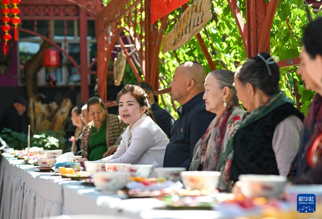 喀拉亚尕奇村党总支书记阿克波塔&middot;巴合提江（白衣者）在“伊犁人的奶茶会”上发言（5月14日摄）。