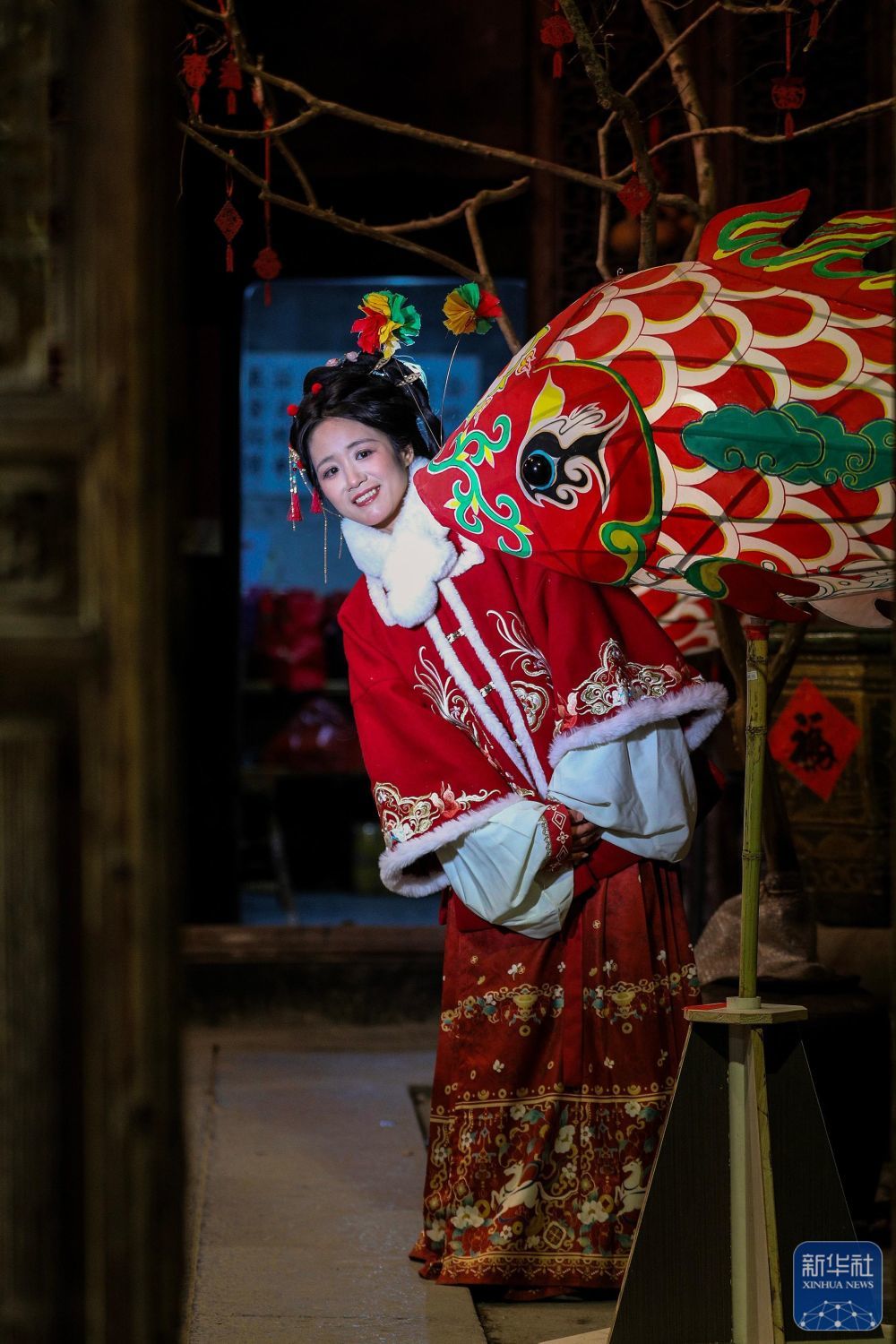 2月7日,游客在瞻淇村和鱼灯合影。