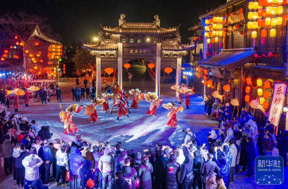 ↑ 1月1日,游客在江苏省盐城市大纵湖旅游度假区的东晋水城观看非遗节目表演(无人机照片)。新华社发(周社根摄)