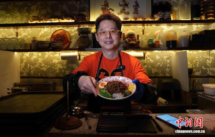 4月10日，郭仟云端出一碗刚做好的卤肉饭。郑子颜 摄