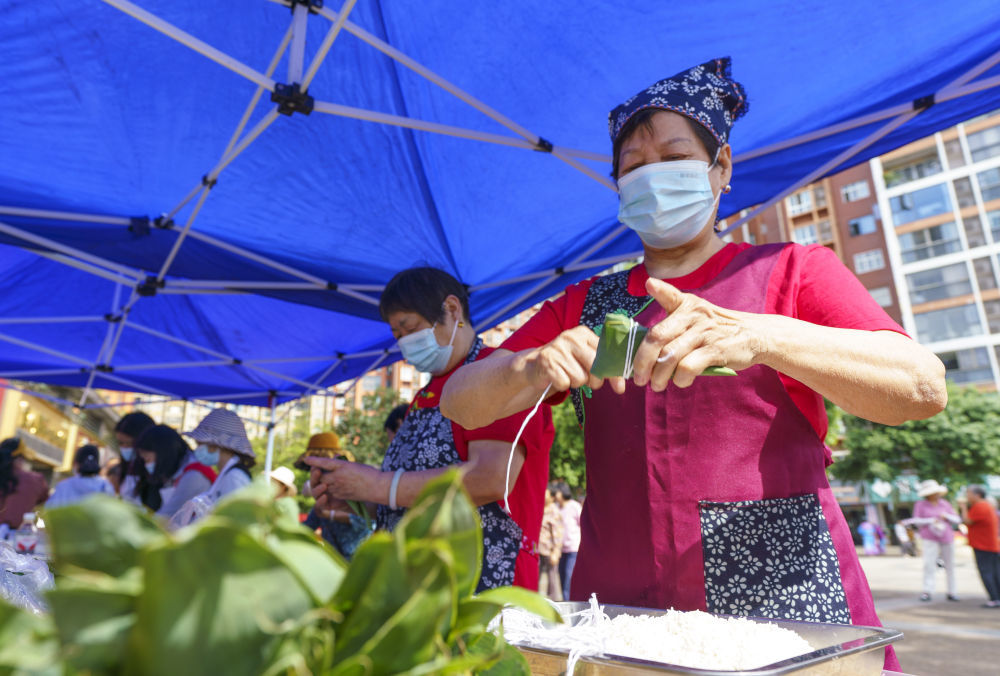 在湖北省宜昌市秭归县茅坪镇滨湖社区,居民正在包传统端午粽。新华社发(周仕伟 摄)