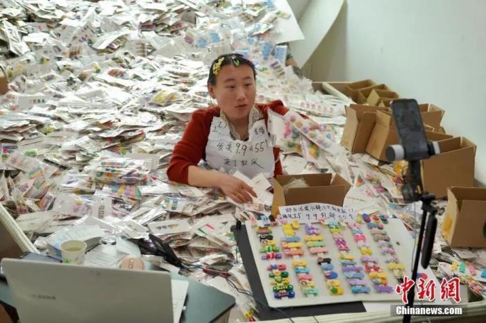 一名主播坐在发夹堆里,对着镜头讲解产品。董易鑫 摄