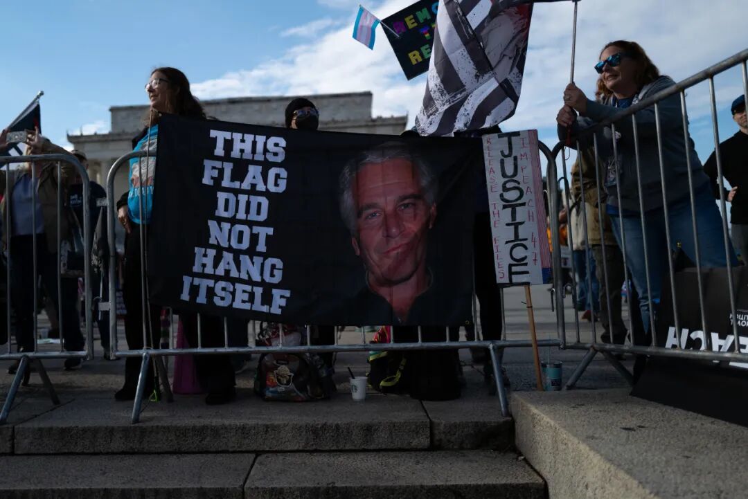 2025 年 11 月 22 日,抗议者在华盛顿特区手持爱泼斯坦画像示威。(法新社)