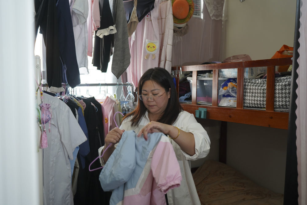2025年11月10日,在元朗攸壆路的“简约公屋”,杜女士在家中整理衣物。新华社发(谭佳铭 摄)