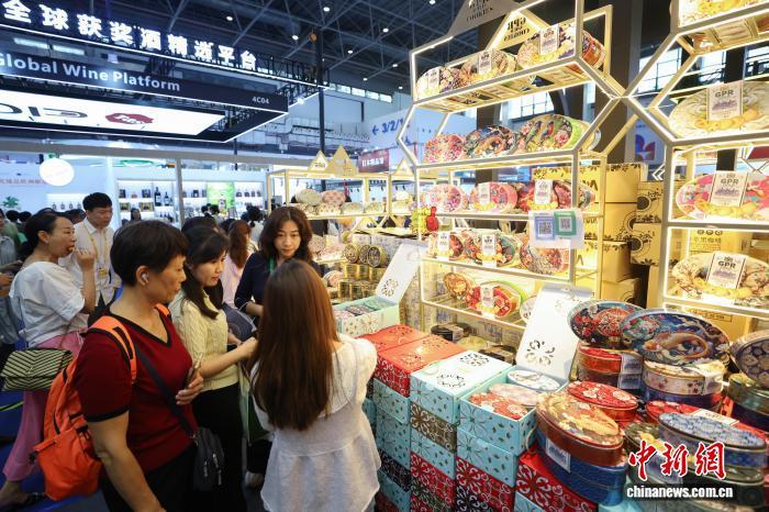 4月15日，第六届中国国际消费品博览会正在海南海口举行，图为参观者在马来西亚精品馆选购曲奇饼干。　杨郁然 摄
