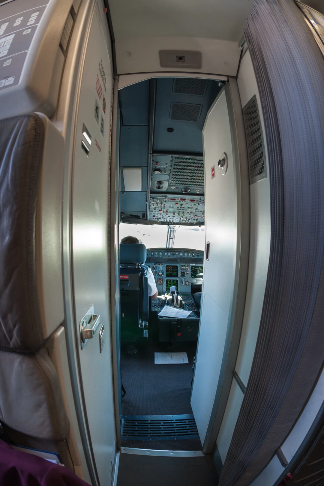 现代民航客机的加固驾驶舱门(图为空客 A319 舱门,打开状态可见内部驾驶舱)。9·11 之后,驾驶舱门改为防弹、防撞的电子锁门,只能从内部解锁——这把"坚固的堡垒"却在此次 FZ1073 事件中成了一道从内部被攻破的门 | 维基共享