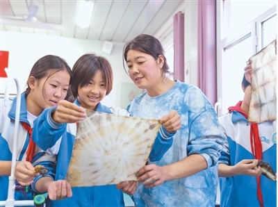 河北沧州市新华区新兴小学的学生在文艺志愿者指导下体验扎染技艺。　　刘友辉摄