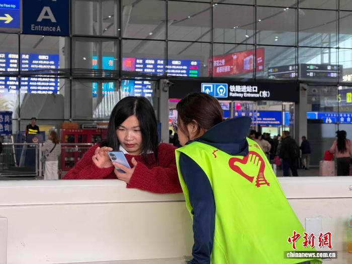 志愿者为旅客提供咨询服务。 田恬 摄