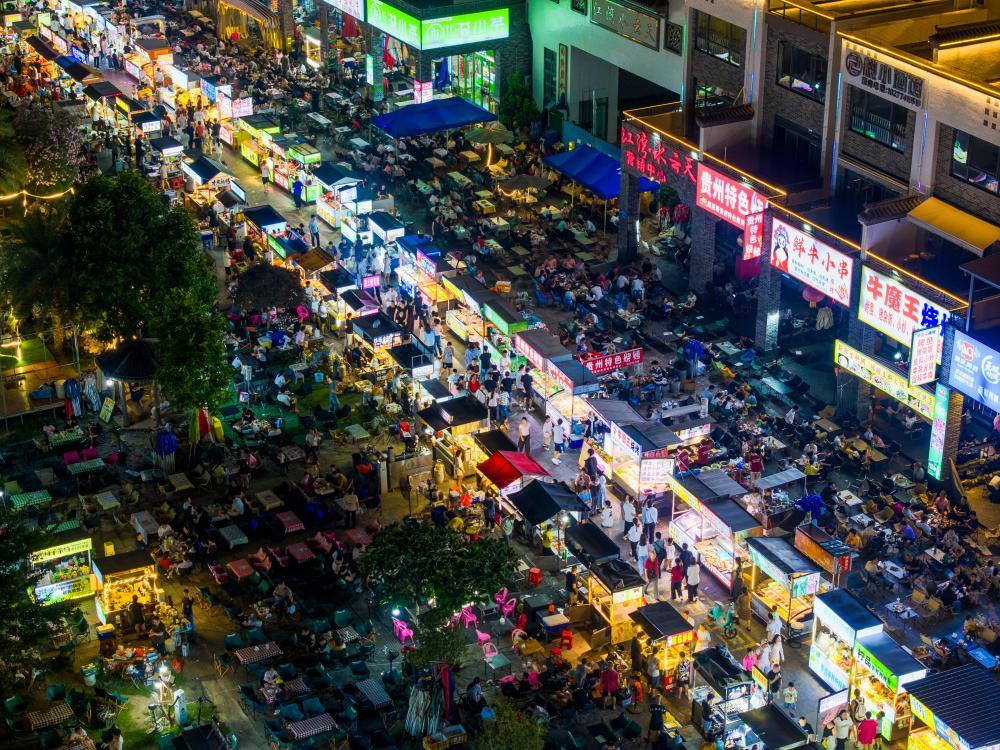 10月2日晚,人们在广西梧州市水云天夜市品尝小吃(无人机照片)。 新华社发(何华文摄)