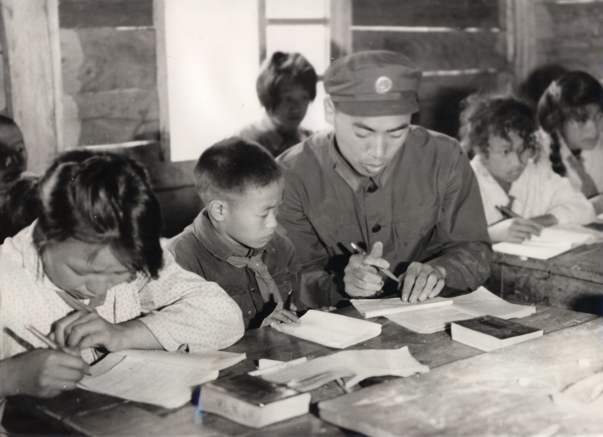 图为上世纪60年代，独龙江边防战士正在给孩子们辅导作业