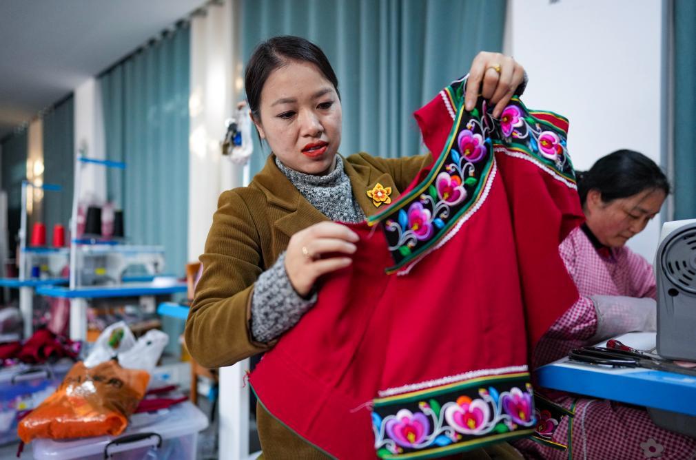 金瑞瑞在自己的工作室内查看彝绣服饰。新华社记者 陈欣波 摄