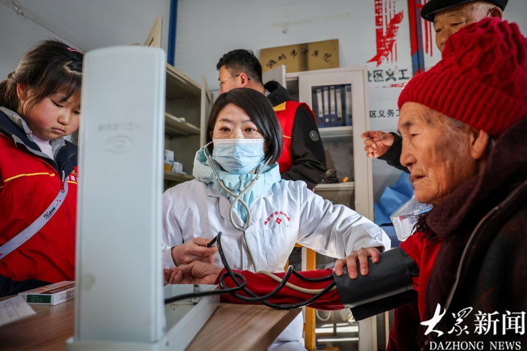 志愿者为88岁的李元花量血压。