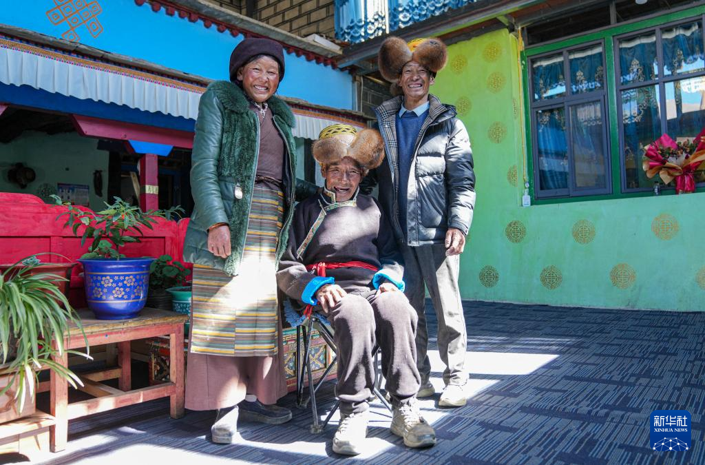 白玛扎西（中）和女儿、女婿在家中合影（3月26日摄）。