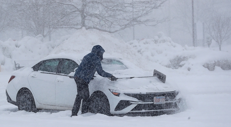 2026年1月25日中午,马什菲尔德市一名司机在出发前清理车上积雪。 东方IC