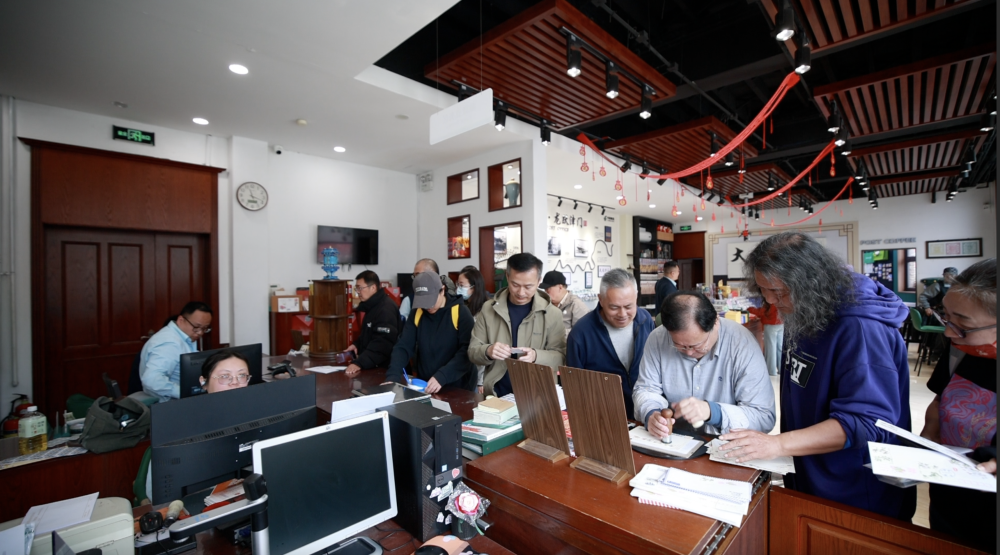 大龙邮局内，游客们给明信片盖上纪念戳。新华社发（胡震泽 摄）