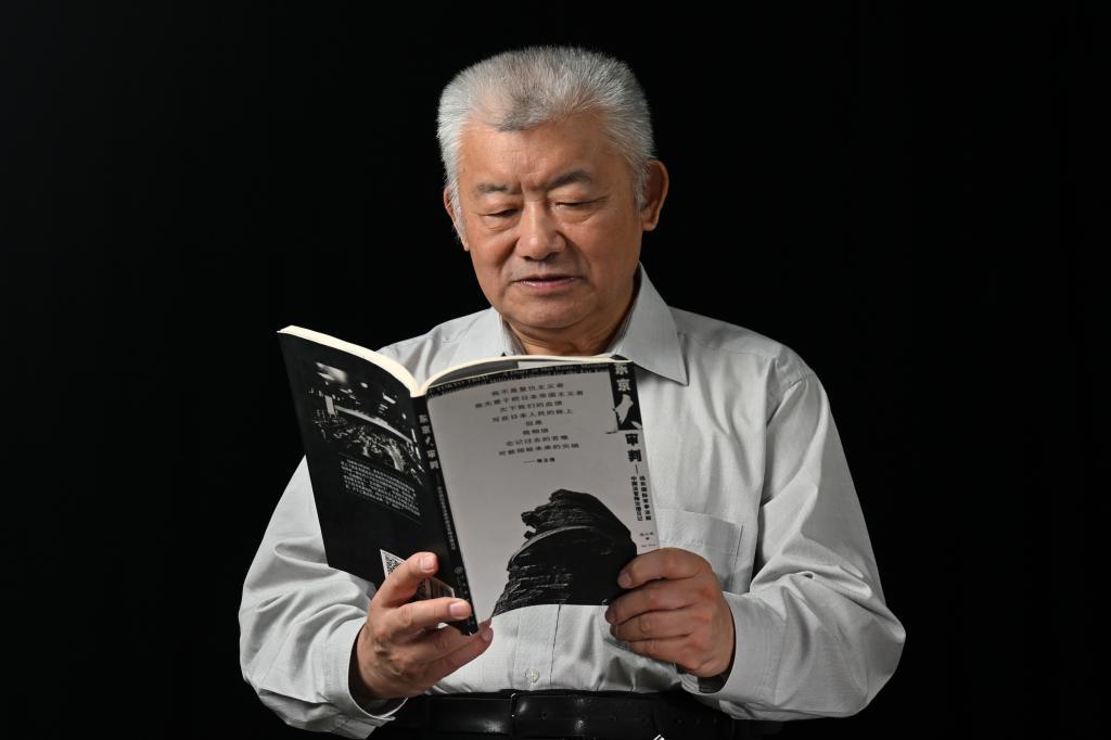 2025年8月8日，梅小璈在阅读父亲梅汝璈所著书籍《东京大审判——远东国际军事法庭中国法官梅汝璈日记》。新华社记者 陈浩明 摄