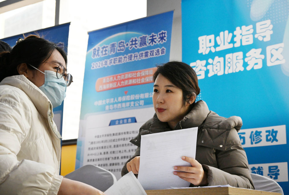 1月30日，在山东省青岛西海岸新区人力资源大市场就业指导咨询服务区，工作人员为求职者答疑解惑。新华社记者 李紫恒 摄