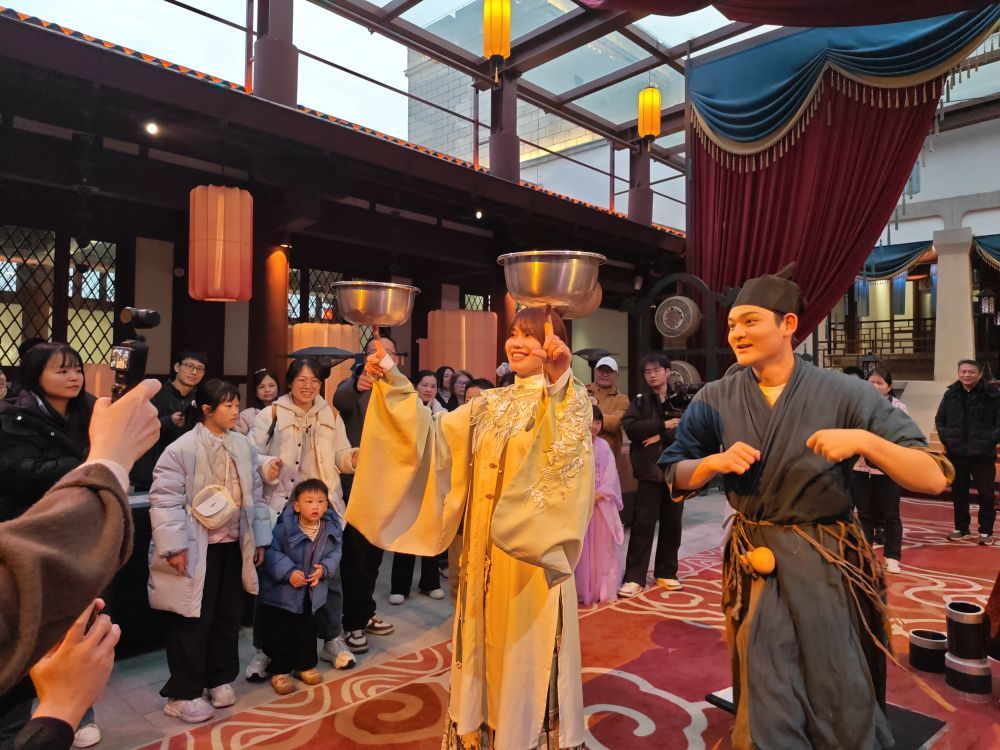 一位来自台北的游客（中）在知音殿工作人员的帮助下体验杂技（3月8日摄）。新华社发（张清硕摄）