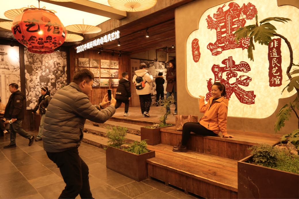 市民在十八梯非遗民艺馆打卡拍照（央广网发 周长江 摄）
