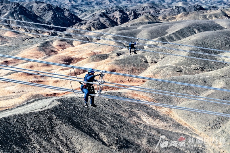工作人员在对哈密-重庆±800千伏特高压直流输电工程的导线间隔棒进行检查。(资料图)图/新疆送变电有限公司提供