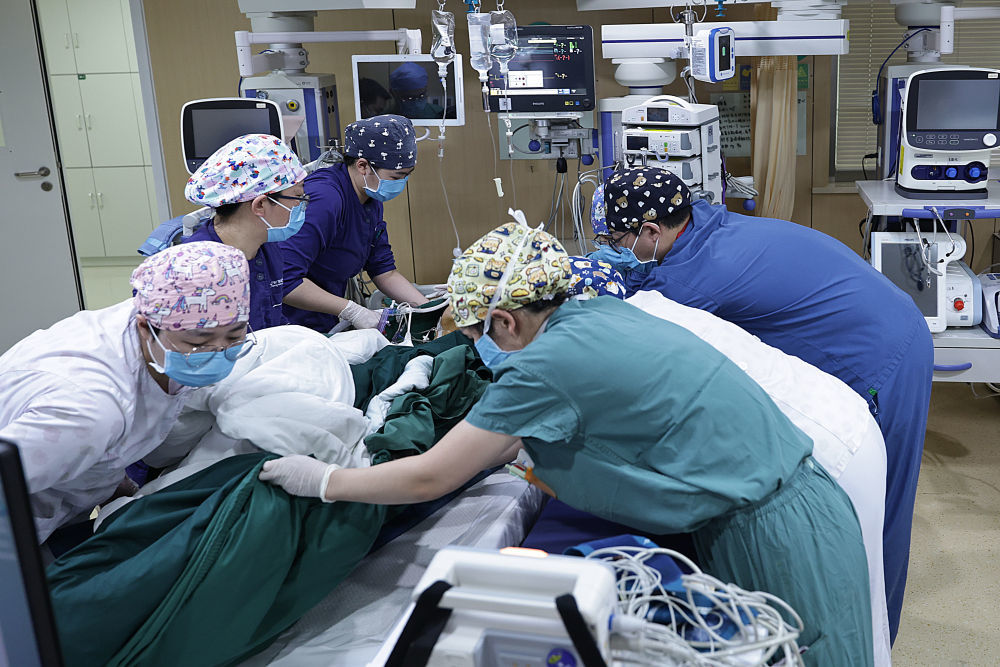 2月4日2时许，重症监护室和手术室护士们合力将一名刚刚做完手术的病人转移到病床上。