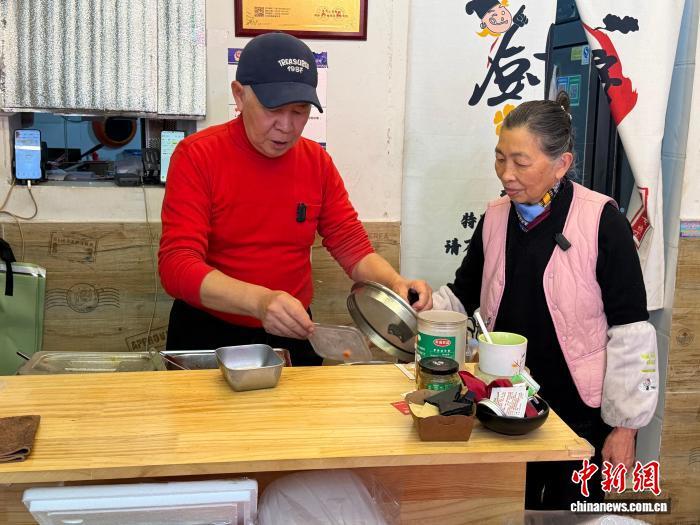 3月11日，台胞刘韦麟(左)与妻子吴微微在他们位于成都市郫都区的“宝岛饭馆”内忙碌。 中新社记者 岳依桐 摄
