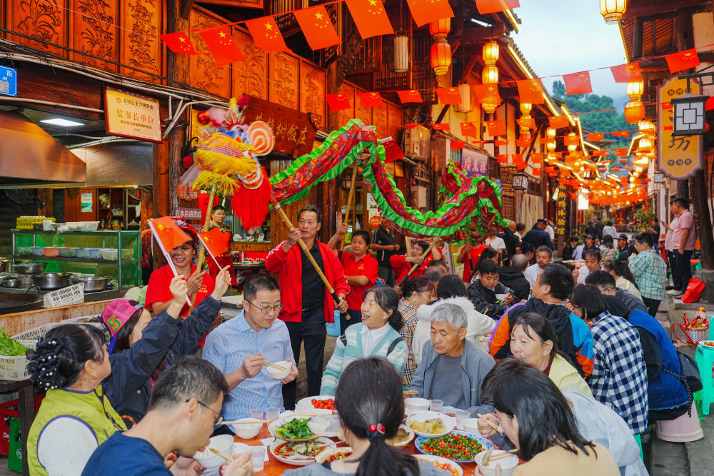 10月1日,在重庆市北碚区金刀峡镇偏岩古镇长街宴上,民间艺人表演舞龙。新华社发(秦廷富 摄)