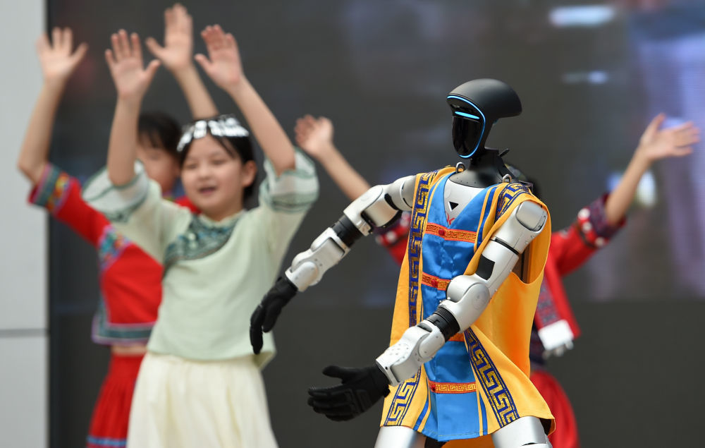 2026年4月13日，在广西南宁市滨湖路小学举行的“情系‘三月三’ 同心向未来”主题活动上，机器人和学生一起表演节目。