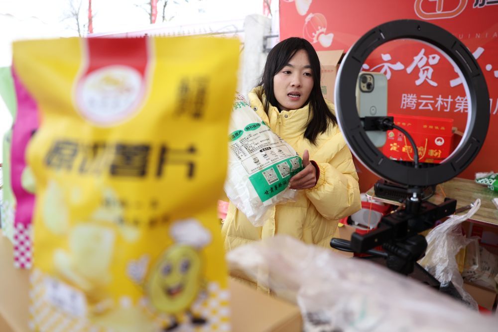 自媒体博主蔡雪芳在年货大集上通过直播带货的方式推介定西宽粉（1月19日摄）。新华社记者 陈斌 摄