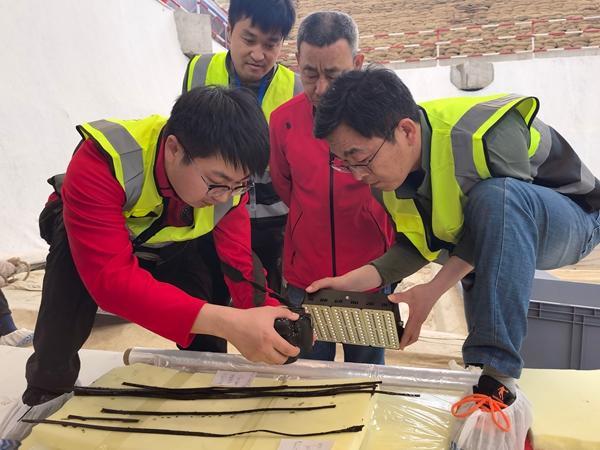 团队成员使用红外相机观察首次出土的竹简。从左至右分别是：柴政良、张闻捷、赵卫东（安徽省文物考古研究所工作人员）、赵瑞辉（安徽省文物考古研究所工作人员，拿着红外补光灯）。受访者供图