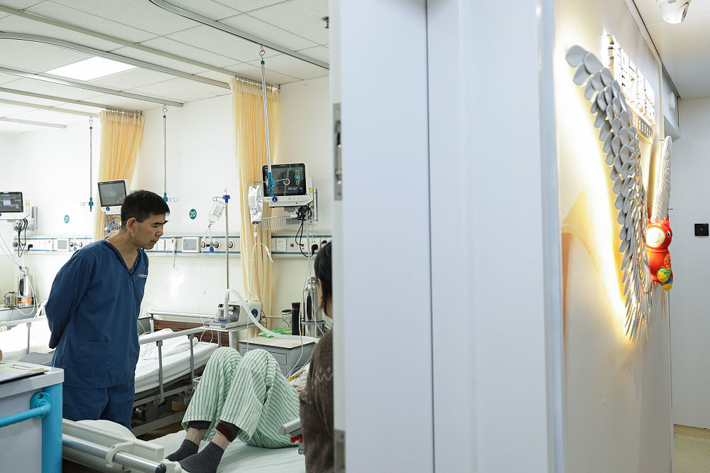 2月9日10时许，急诊科资深主任齐文生（左）在急诊病房查房。